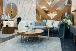 Table d'appoint avec plateau en bois vernis noyer et piètement en acier inoxydable couleur chrome.