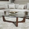 Table basse avec plateau en verre trempé noir et piètement en bois noyer.