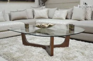 Table basse avec plateau en verre trempé noir et piètement en bois noyer.