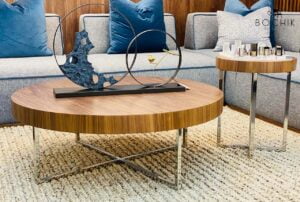 Table d'appoint avec plateau en bois vernis noyer et piètement en acier inoxydable couleur chrome.